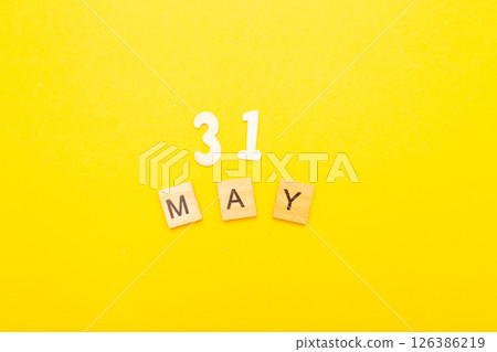Top view of word 31 May calendar date made by wooden cubes on yellow color background Top view of word 31 May calendar date made by wooden cubes on yellow color background 126386219