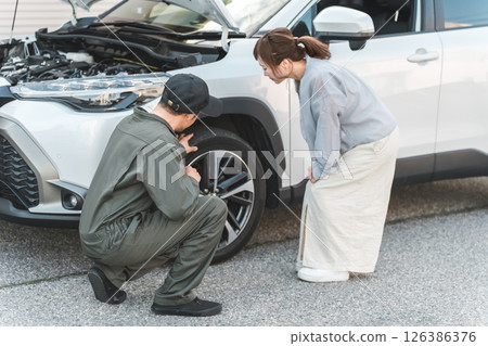 A male worker and a female driver rushed to the road for road service. 126386376