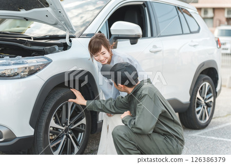 一名男工人和一名女司機趕到路上進行道路服務。 126386379