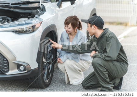 A male worker and a female driver rushed to the road for road service. 126386381