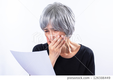 一位老婦人一邊哭一邊讀信 126386449