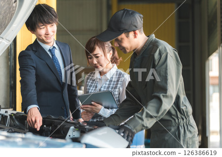 身穿西裝的年輕亞洲商人向維修店的機械師提問 126386619