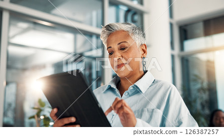 Business, finance and tablet with mature woman in office for administration, planning or research. App, development and report with happy professional in corporate workplace for review of information 126387257
