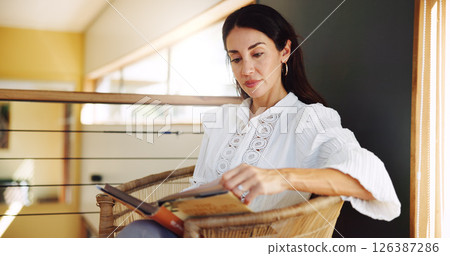 Mature woman, home and reading book on chair for literature hobby, magazine and fiction story to relax. House, comfortable and female person with novel on break for fantasy, learning and knowledge 126387286