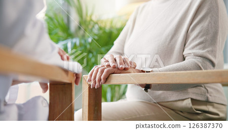 Chair, conversation and hands of doctor with senior outdoor in garden of home for healthcare or retirement. Break, checkup or consulting with medical professional speaking to patient in backyard 126387370