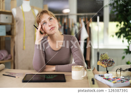 Tired dressmaker worker at table Tired dressmaker worker at table 126387391