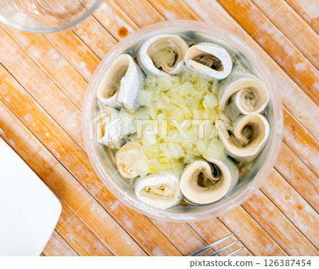 Pieces of pickled herring served with onions 126387454