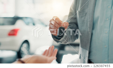 Dealership, salesman and customer with hands for car keys, test drive and success purchase of motor. Showroom, people and giving equipment in closeup for buying vehicle, rental service and automobile 126387455