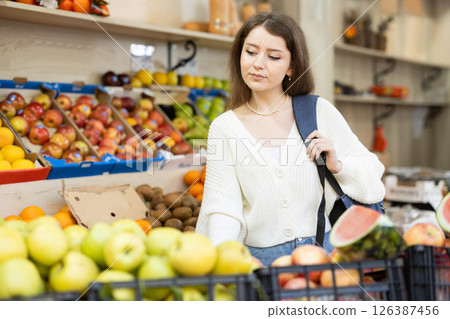Young woman choosing apples at vegetable market 126387456