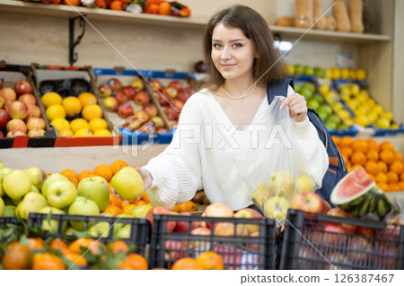 Young woman choosing apples at vegetable market Young woman choosing apples at vegetable market 126387467