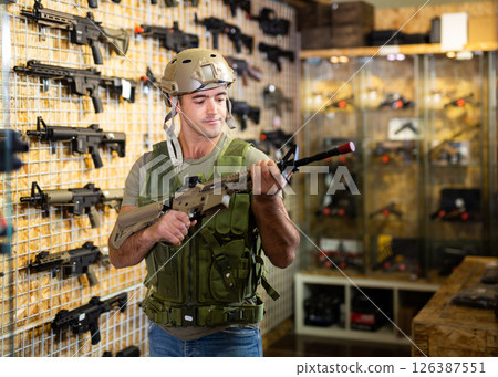Man in armor choosing weapon in arms shop Man in armor choosing weapon in arms shop 126387551