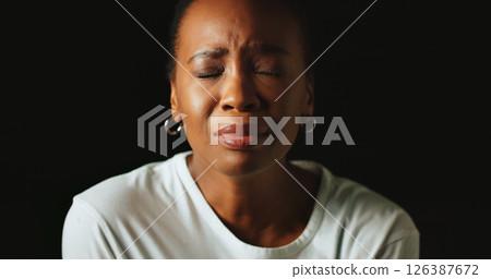 Closed eyes, sad and black woman in studio, crying and mental health on dark background. African person, mockup space or model with tears, anxiety and depression with grief, upset or stress with loss 126387672