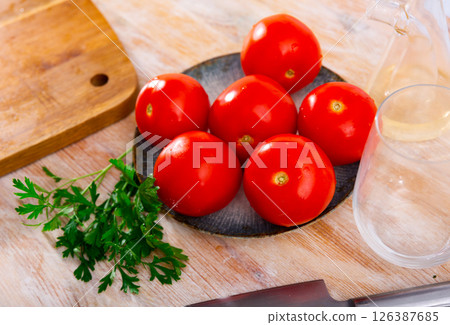 Delicious tomatoes on a plate, decorated with fresh parsle Delicious tomatoes on a plate, decorated with fresh parsle 126387685