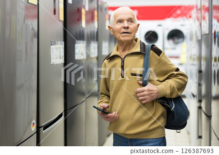 Elderly man choosing refrigerator in showroom of electrical appliance store 126387693