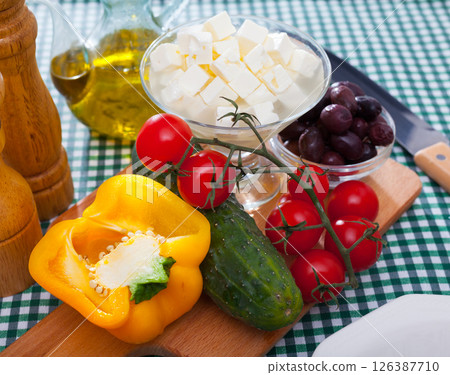 Cooking Greek salad with mozzarella cheese. Ingredients on the table Cooking Greek salad with mozzarella cheese. Ingredients on the table 126387710