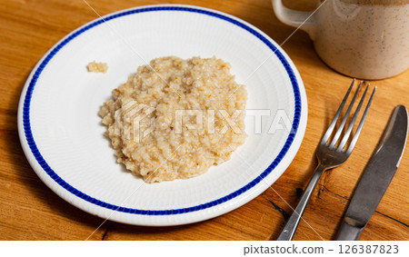 There is portion of freshly prepared milk oatmeal porridge in plate There is portion of freshly prepared milk oatmeal porridge in plate 126387823