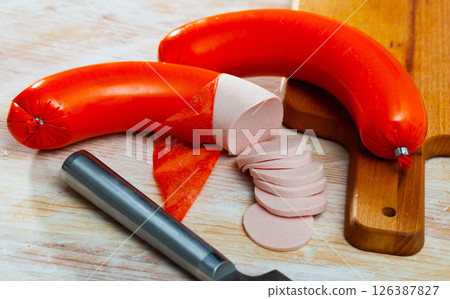 Mortadela sausage cut in slices on a wooden surface 126387827