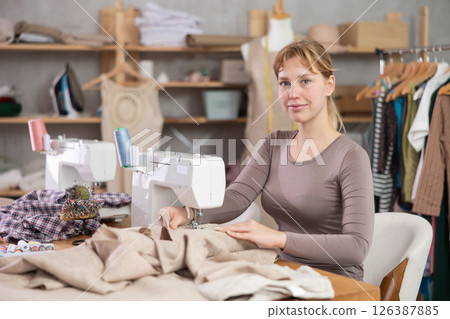 Woman tailor working at sewing machine Woman tailor working at sewing machine 126387885
