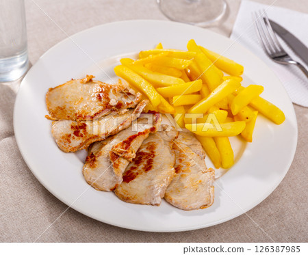 Pork chop with French fries on a plate. Pork chop with French fries on a plate. 126387985