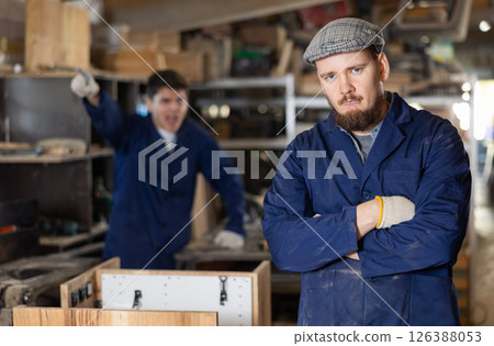 Disgruntled furniture factory owner yells at careless worker Disgruntled furniture factory owner yells at careless worker 126388053