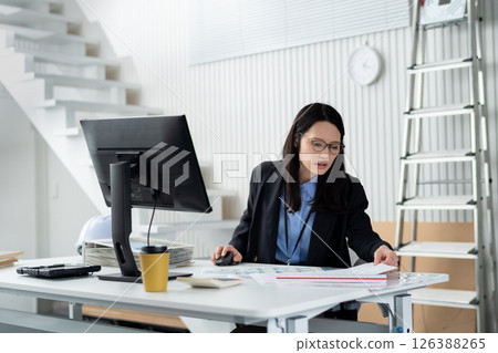 一名婦女在工作時攤開與建築相關的文件 126388265