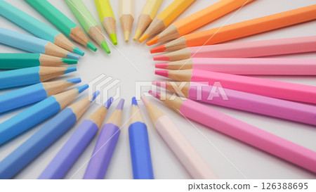 a clean, Heart composition of colored pencils arranged in a vibrant gradient spectrum from cool blues and greens to warm yellows, oranges, and pinks 126388695