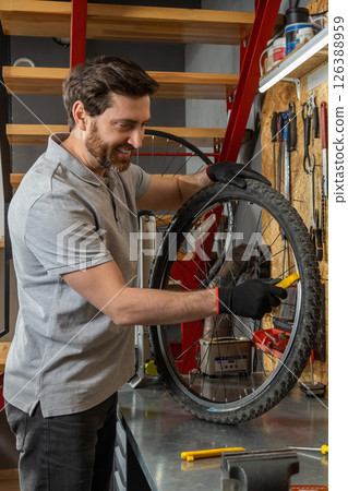 Mechanic in black gloves inspecting wheel 126388959