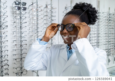 Curly-haired african american female optician in eyeglasses 126389041
