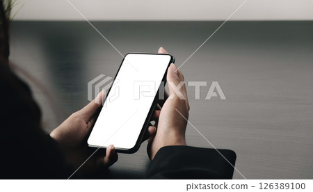Top view Woman sitting and holding blank screen mock up mobile phone Top view Woman sitting and holding blank screen mock up mobile phone 126389100