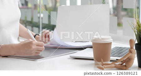 Close up view of female designer hands typing on computer laptop while working at modern startup office. Close up view of female designer hands typing on computer laptop while working at modern startup office. 126389121