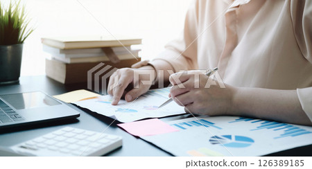 woman checking paperwork from accounting department to analyse number on document, using laptop check business database, information comparing. Typing keyboard for recording woman checking paperwork from accounting department to analyse number on document, using laptop check business database, information comparing. Typing keyboard for recording 126389185