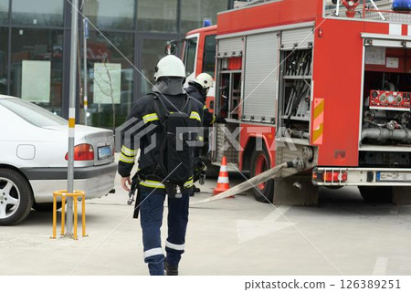 Firefighter Wearing SCBA Walking Toward Fire Engine Firefighter Wearing SCBA Walking Toward Fire Engine 126389251