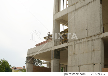 Multistory Concrete Building Under Construction With Worker 126389337