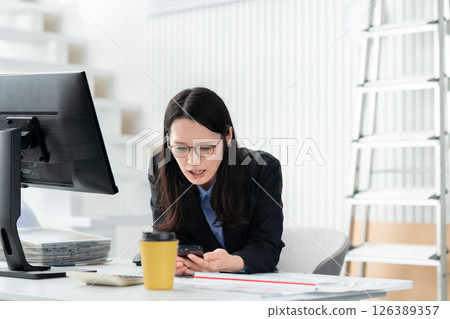 A construction company employee with a smartphone looking troubled A construction company employee with a smartphone looking troubled 126389357