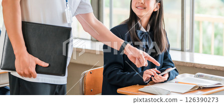 A teacher and a female student teaching using a smartphone (BYOD/ICT) 126390273