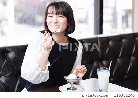 Woman eating ice cream in a cafe 126391246