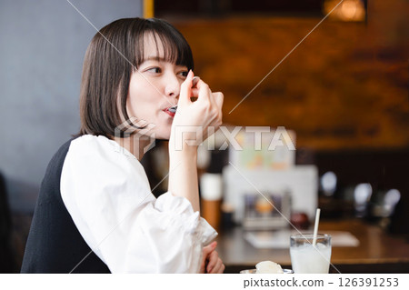 Woman eating ice cream in a cafe 126391253