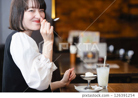 Woman eating ice cream in a cafe 126391254