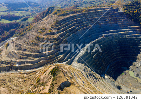 Flying above an open pit mine, copper excavation in Rosia Poieni, Romania. Aerial view Flying above an open pit mine, copper excavation in Rosia Poieni, Romania. Aerial view 126391342