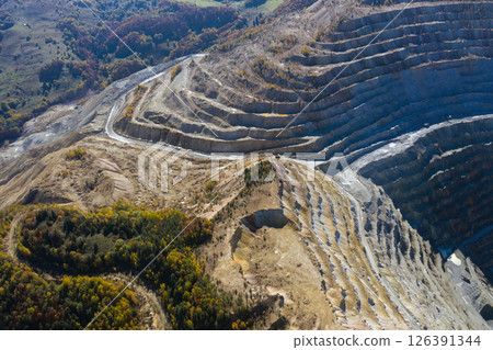 Flying above an open pit mine, copper excavation in Rosia Poieni, Romania. Aerial view Flying above an open pit mine, copper excavation in Rosia Poieni, Romania. Aerial view 126391344