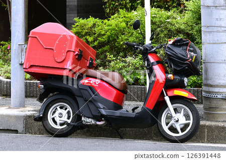 Yokohama cityscape in Japan: A postal delivery bike seen on a street corner (postal worker on delivery) = 16th, Yokohama city 126391448