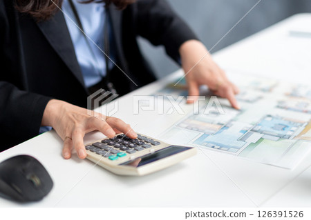 一位女士一邊查看施工文件一邊進行計算 126391526