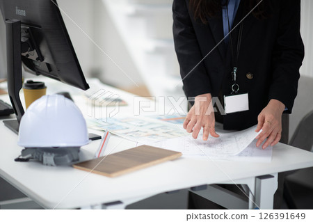 A construction company employee checking a drawing A construction company employee checking a drawing 126391649