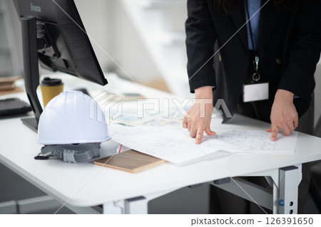 A construction company employee checking a drawing A construction company employee checking a drawing 126391650