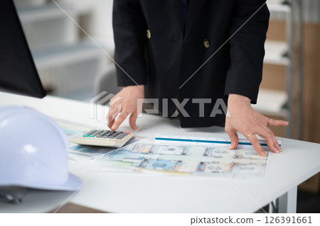 A construction company employee checking a drawing A construction company employee checking a drawing 126391661