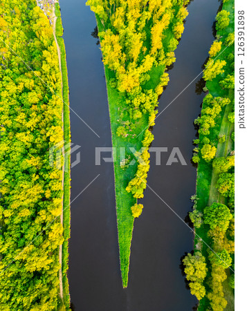 Aerial view captures the merging of the Vltava and Labe rivers by Melnik. Lush greenery surrounds the waterways, showcasing nature's beauty at this serene location. 126391898