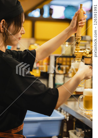 A waiter pouring drinks at the counter 126391991