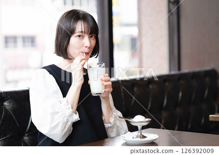 Woman eating ice cream in a cafe Woman eating ice cream in a cafe 126392009