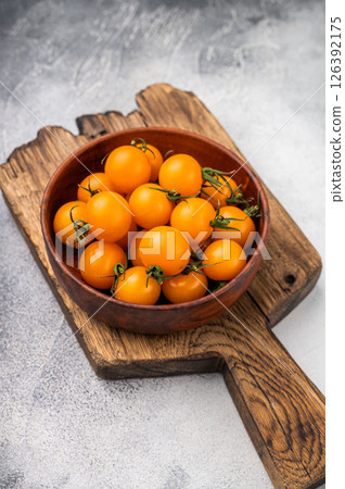 Fresh small yellow cherry tomatoes assortment, mini organic cocktail tomate mix. grey background. top view Fresh small yellow cherry tomatoes assortment, mini organic cocktail tomate mix. grey background. top view 126392175