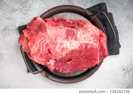 Beautifully arranged raw boneless beef shank pieces on a rustic platter, inviting creativity in the kitchen for delicious slow-cooked meals. grey background. top view Beautifully arranged raw boneless beef shank pieces on a rustic platter, inviting creativity in the kitchen for delicious slow-cooked meals. grey background. top view 126392198